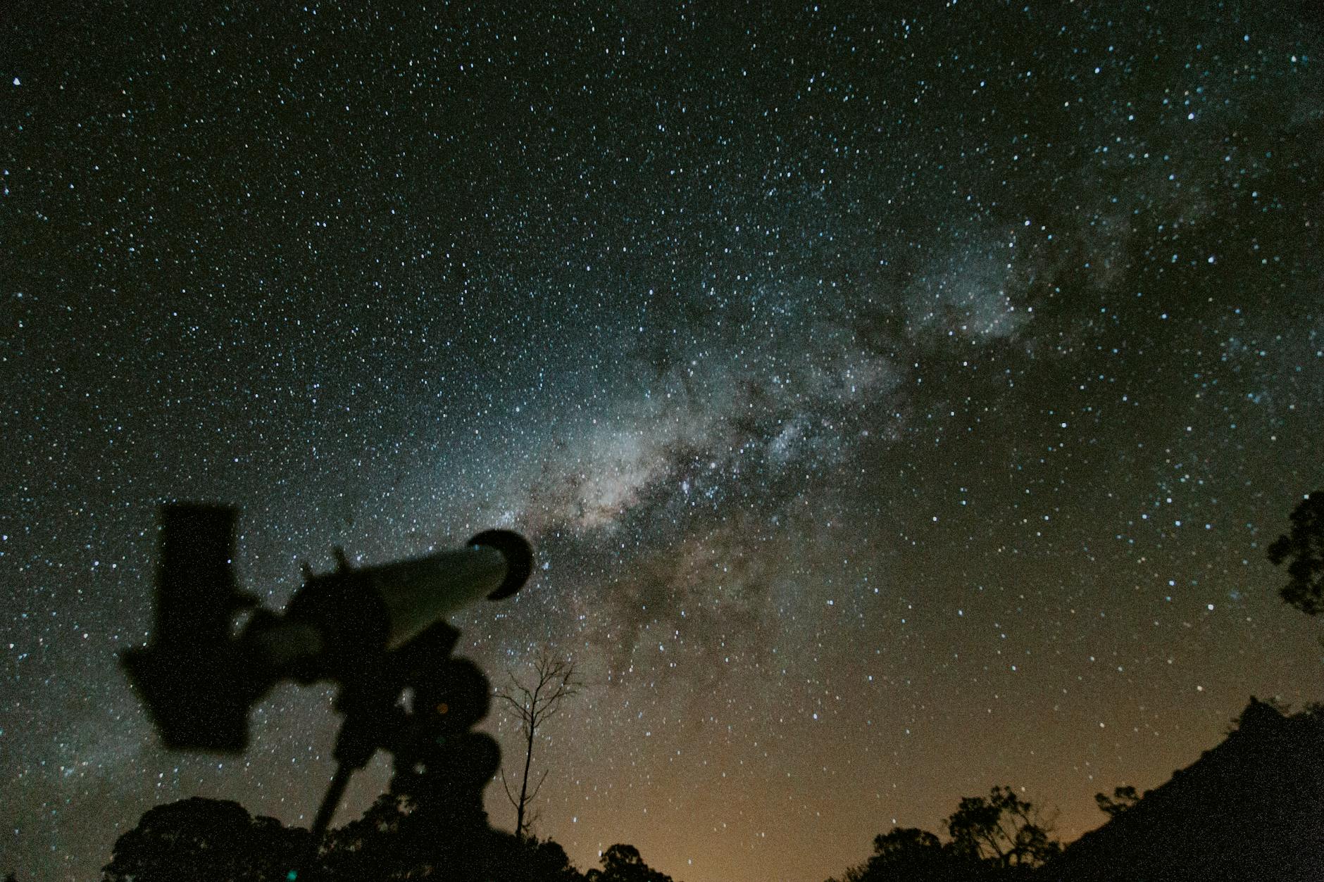 Silhouette d'un télescope avec un arrière-plan magnifique de la voie lactée dans le ciel nocturne.