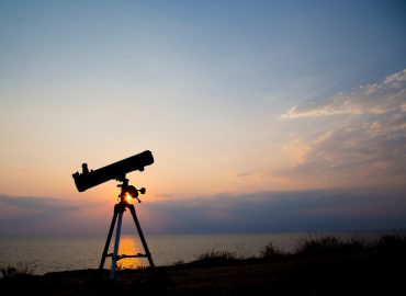 Silhouette de télescope au fond du coucher du soleil, été